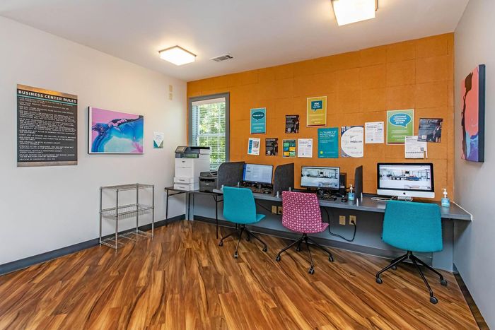 Computer lab with multiple computers and colorful chairs.