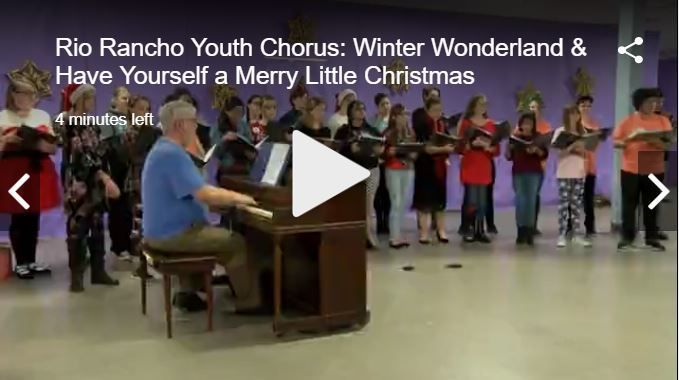 A pianist accompanies the Rio Rancho Youth Chorus in a performance of Christmas songs in a purple-walled hall.