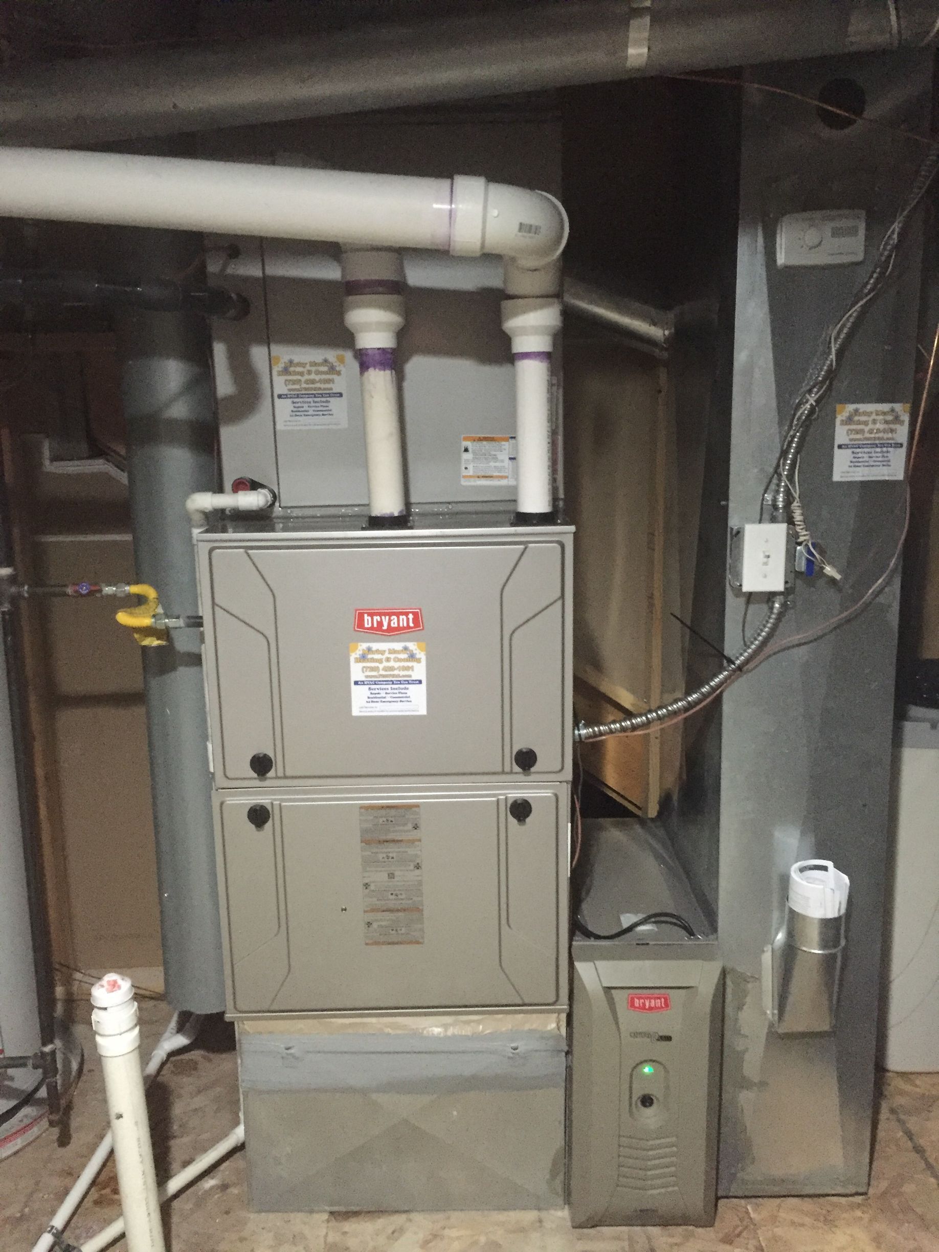White radiator on a green wall, mounted on a light brown wooden floor.