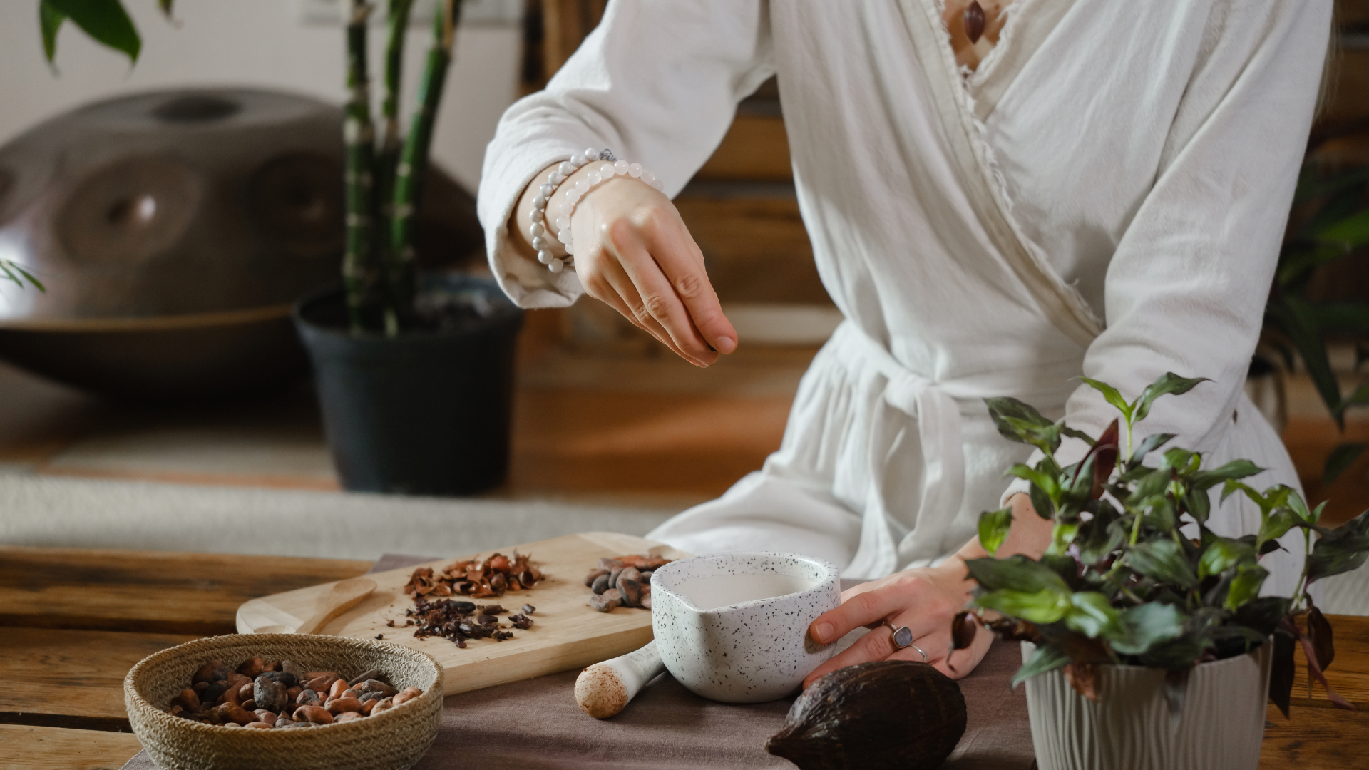 Ceremoniele cacao wordt voorbereid door een dame in een witte jurk. Het is een sereen plaatje.