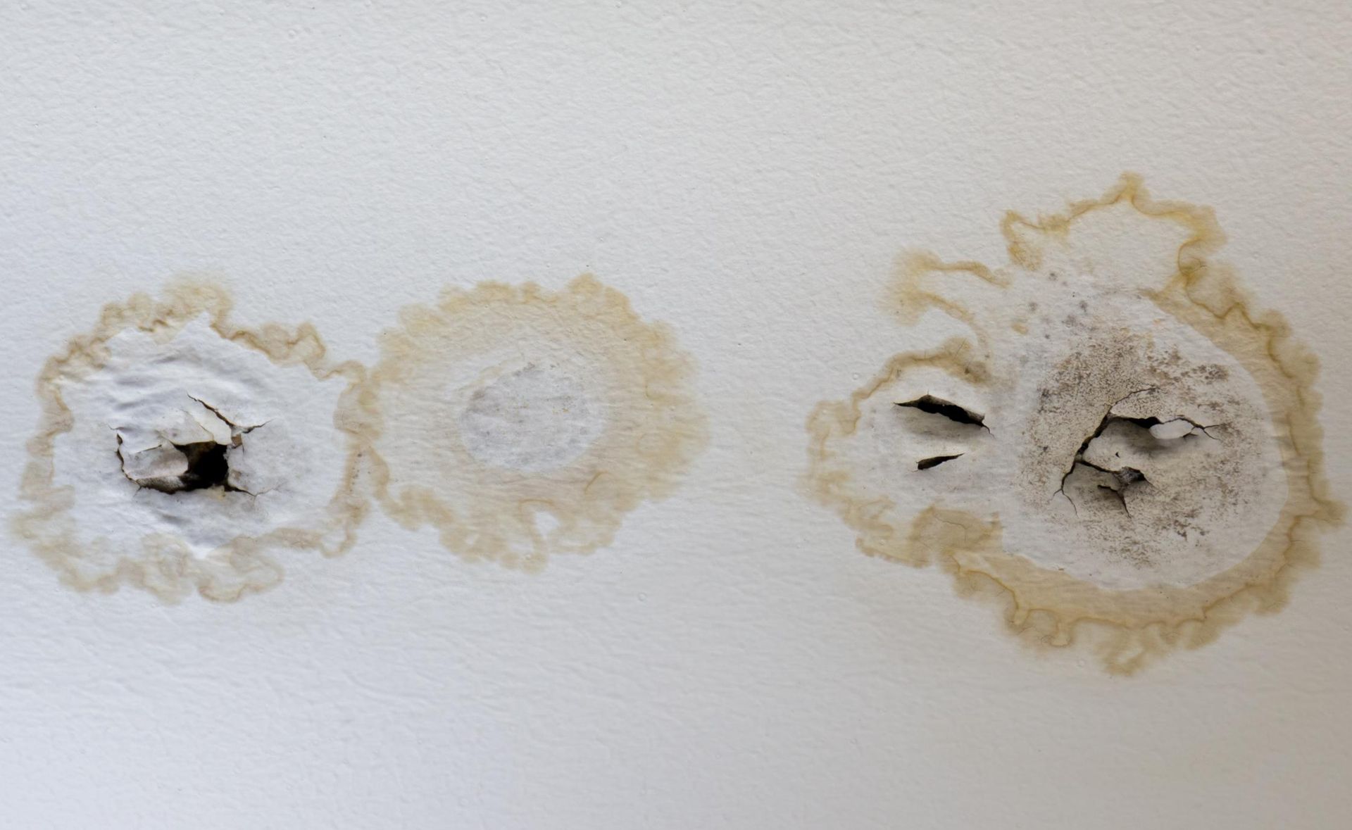 A White Wall With Holes in It and Stains on It — Great Lakes Carpet Cleaning & Restoration In Gloucester, NSW