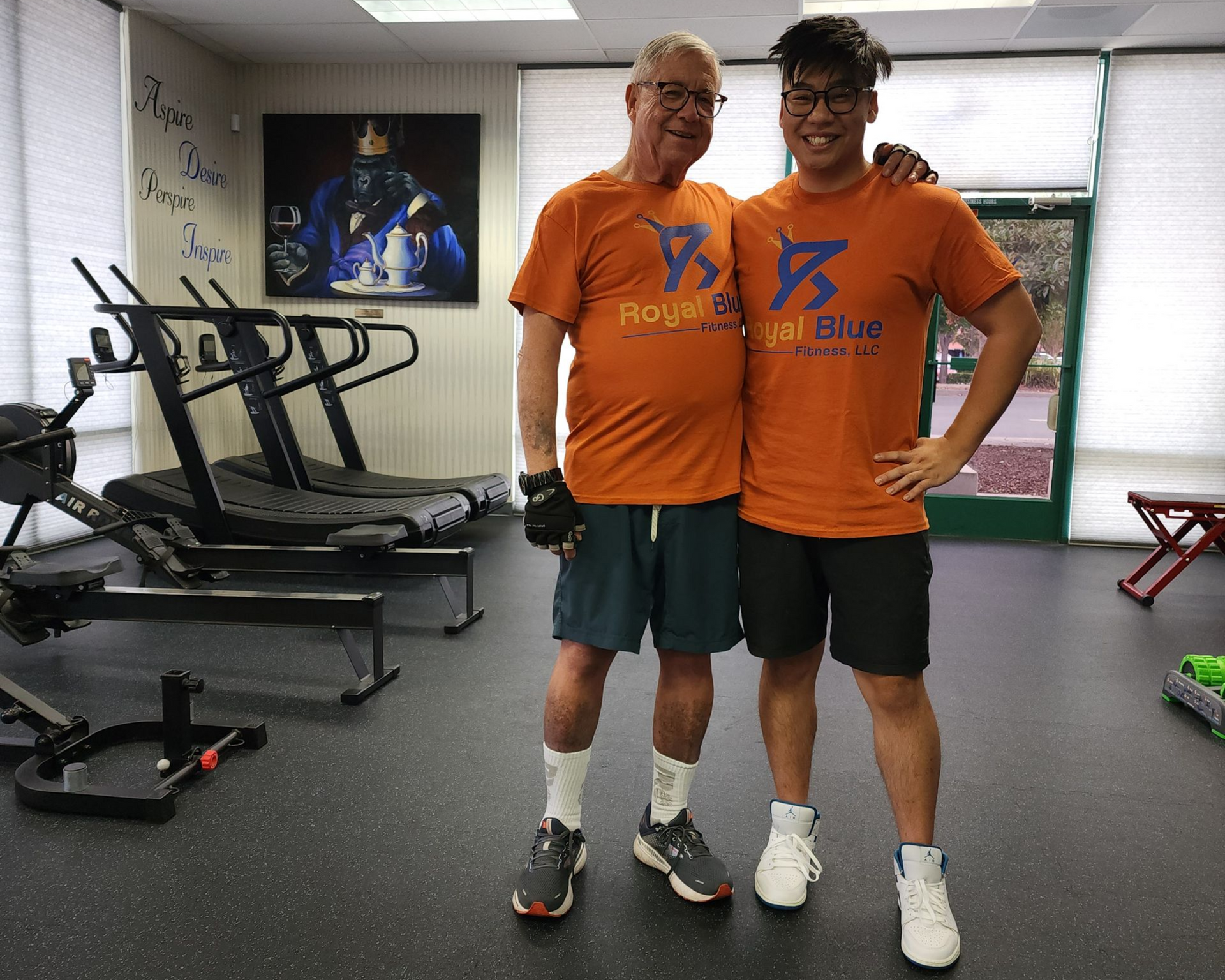 Adult client and coach smiling in the Royal Blue Fitness studio after a training session in Pleasant Hill.