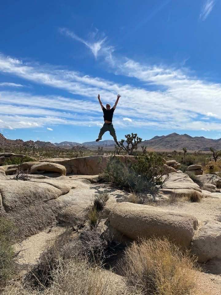 Darrell in the dessert jumping into the air