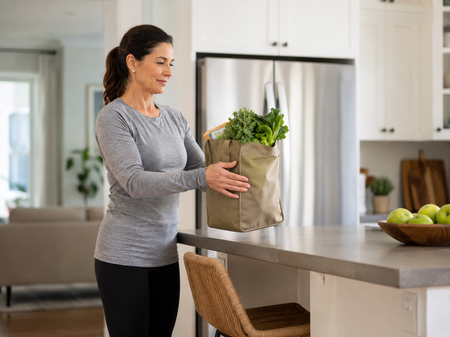 Woman placing a grocery bag on a counter while keeping the load close to her body.