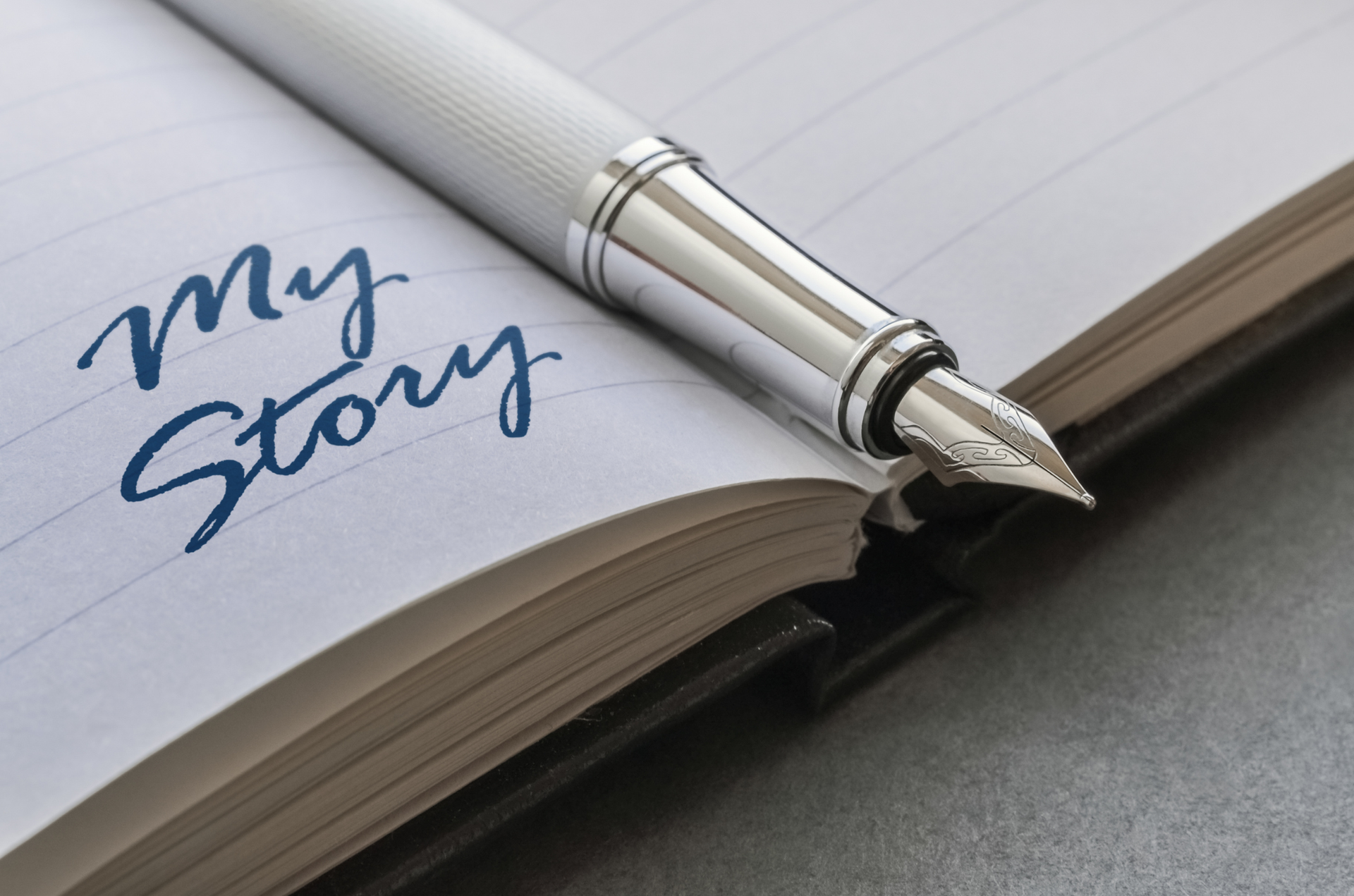 Fountain pen resting on a notebook page that reads ‘My Story.’