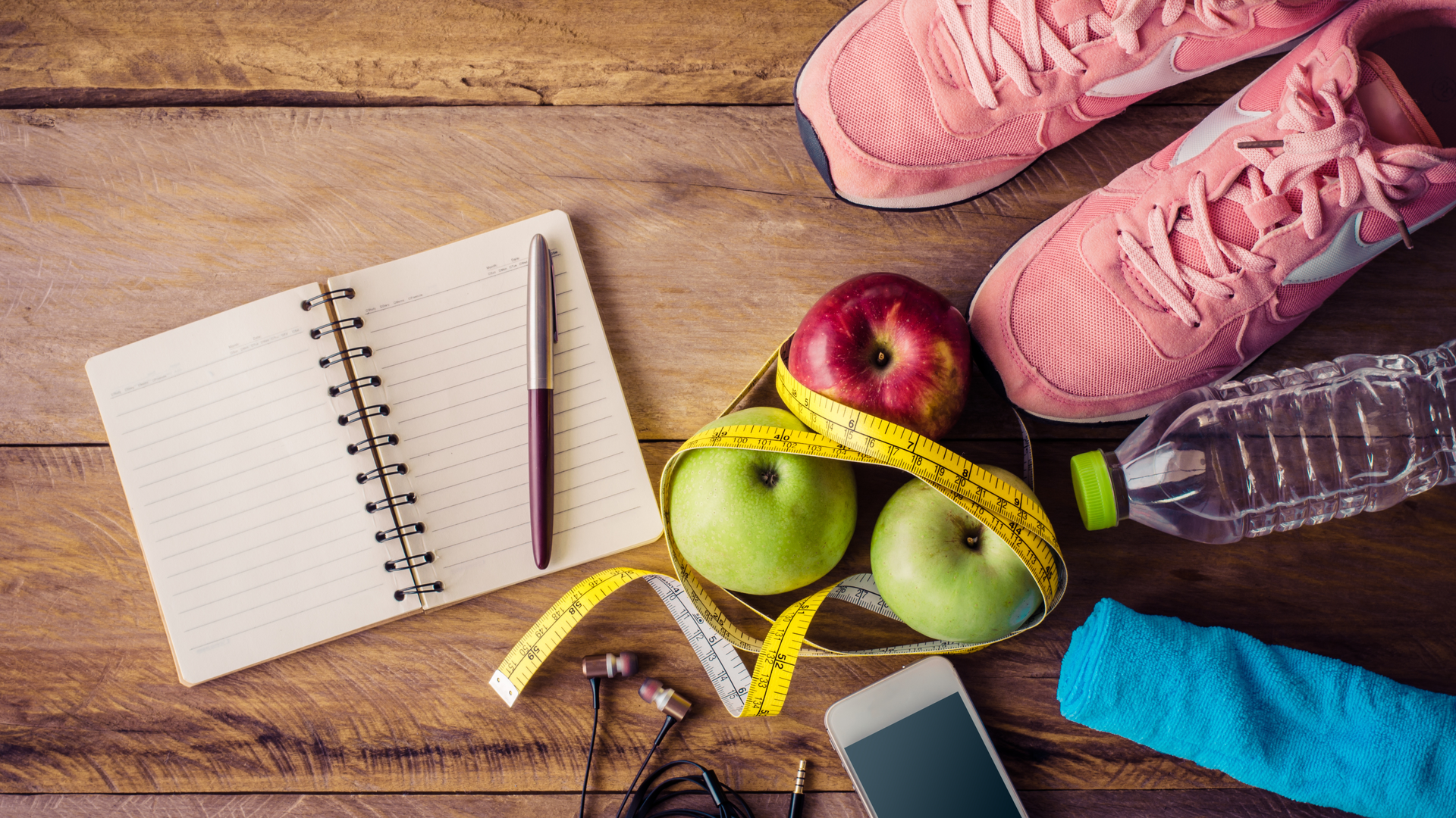 Alt text: Healthy lifestyle flat lay with running shoes, apples, and fitness accessories.