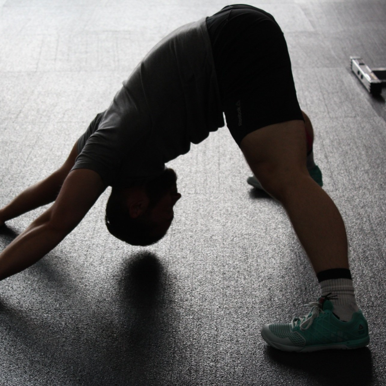 A person stretching their hamstrings, performing a forward bend to improve flexibility and strengthen the hamstring muscles.