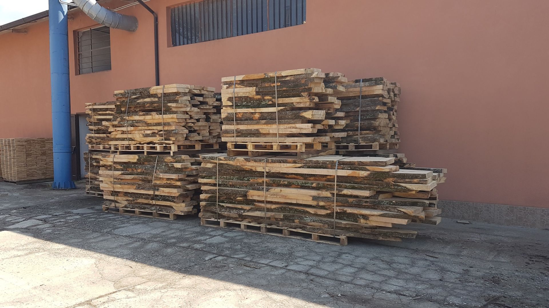 Una pila di pallet di legno è posta di fronte a un edificio.