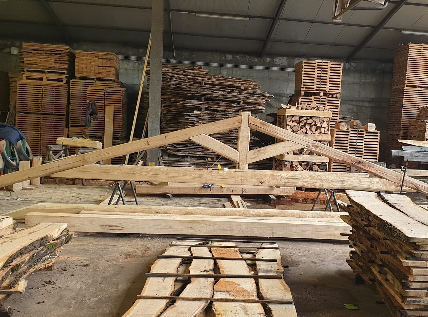 Un magazzino pieno di travi di legno e pallet.