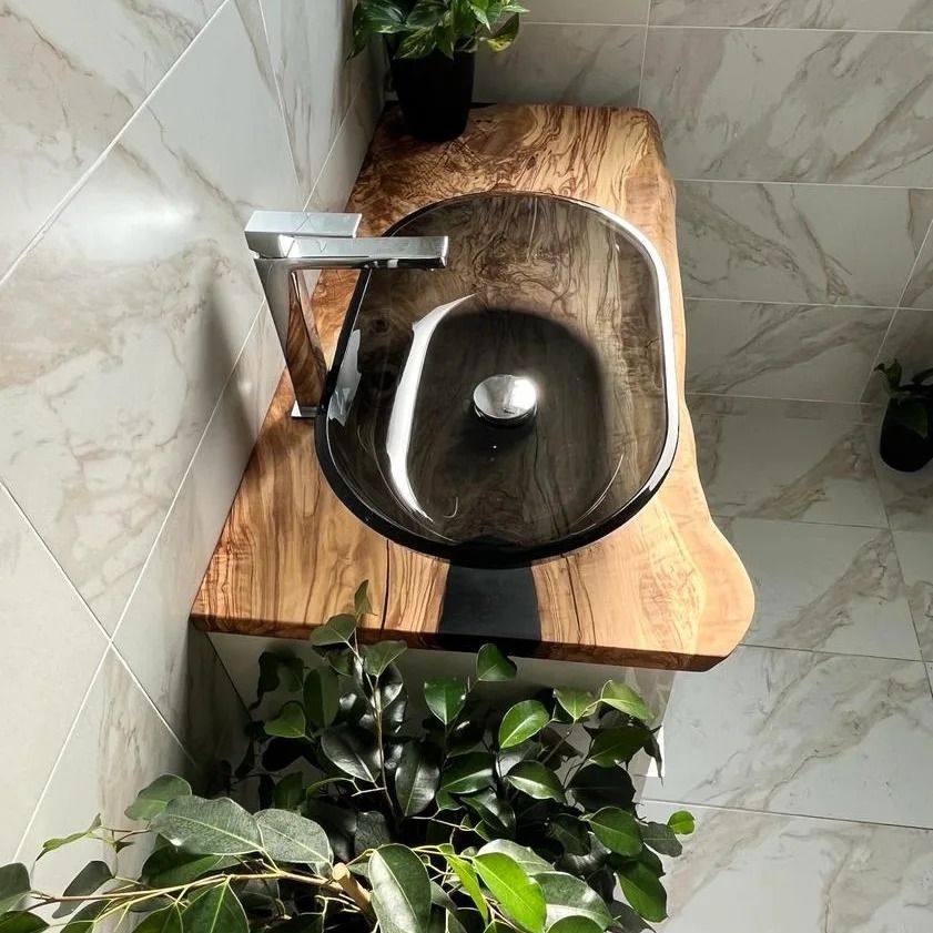 A bathroom sink rests on a wooden countertop.