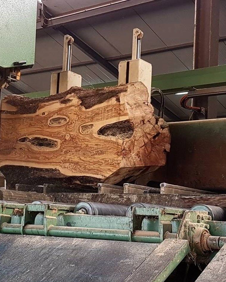 Un grosso pezzo di legno viene tagliato da una macchina