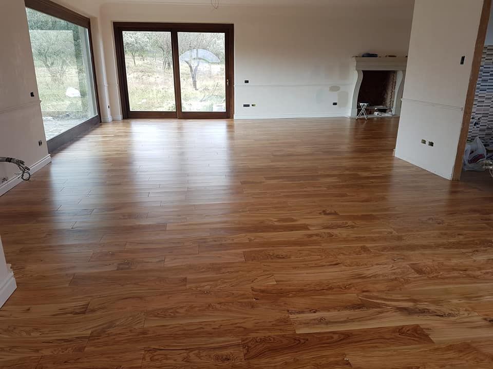 Un soggiorno con pavimento in legno e camino.