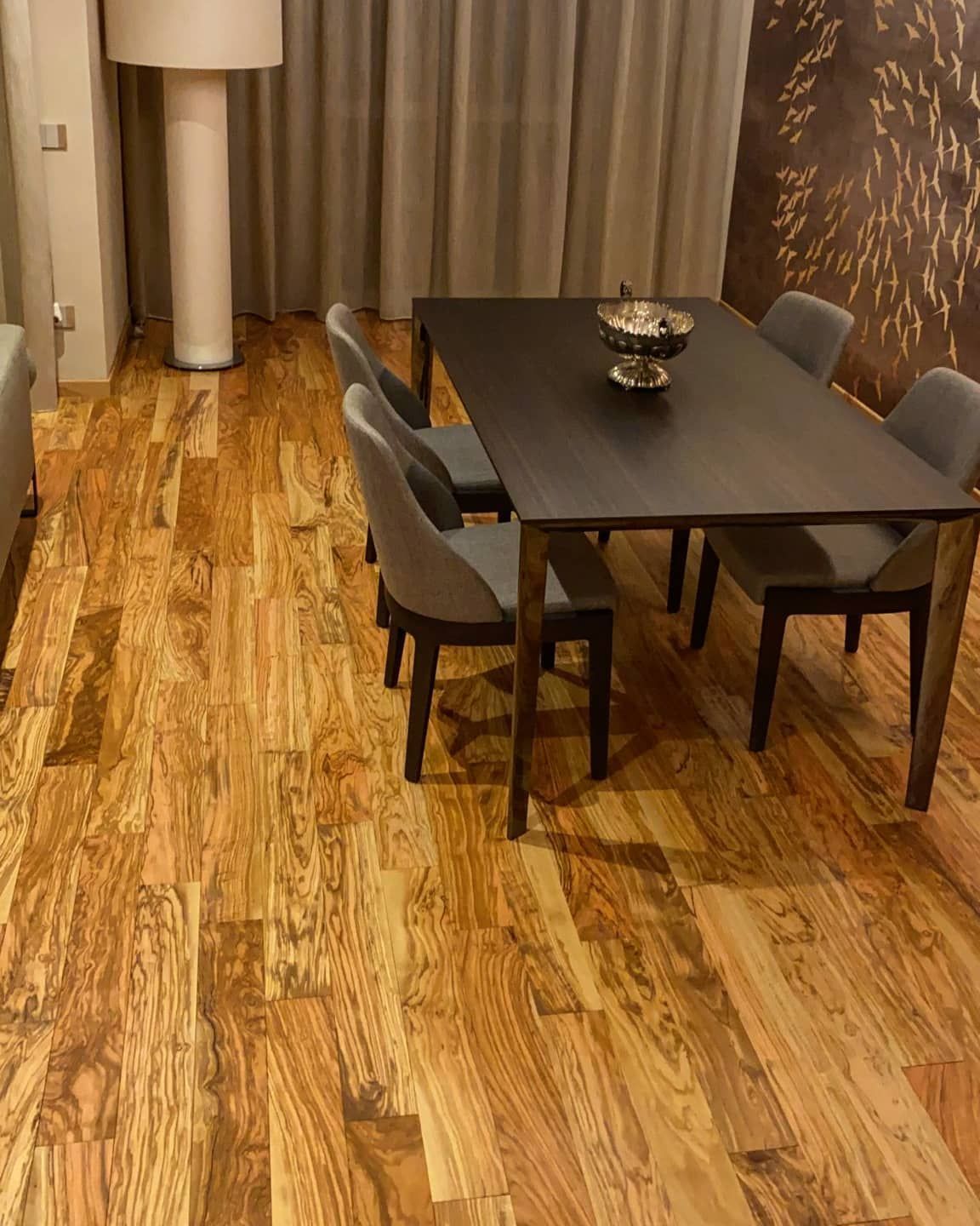 Una sala da pranzo con pavimenti in legno, tavolo e sedie