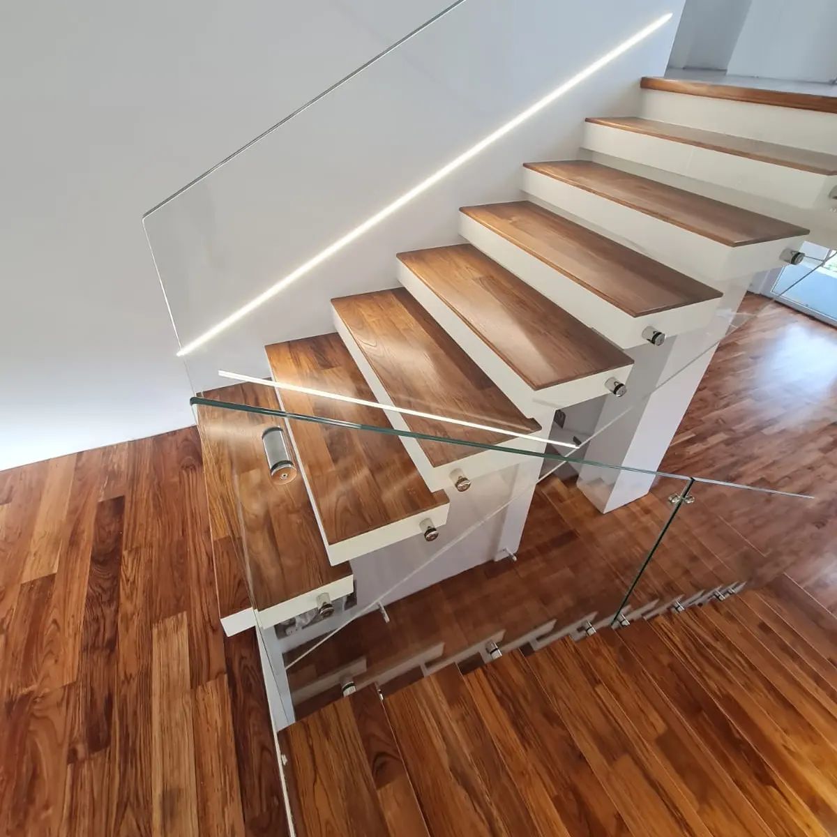 A staircase with wooden steps and a glass railing