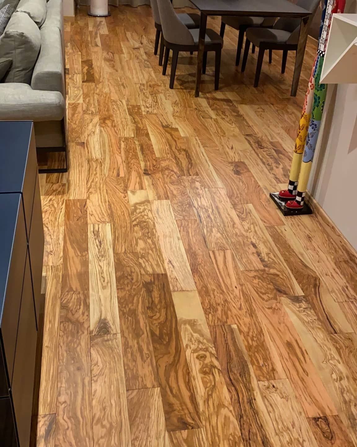 Un soggiorno con pavimenti in legno, un divano, un tavolo e sedie.