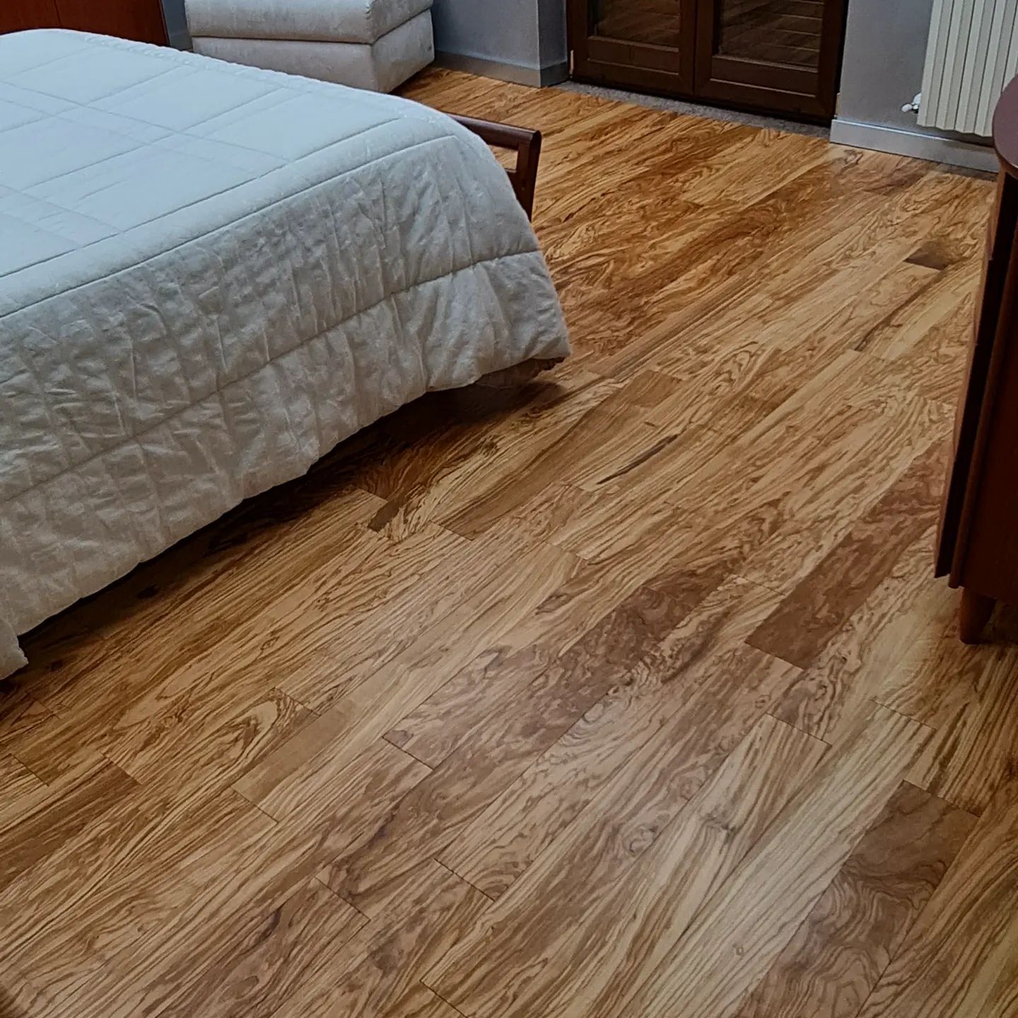 Una camera da letto con un letto e un pavimento in legno