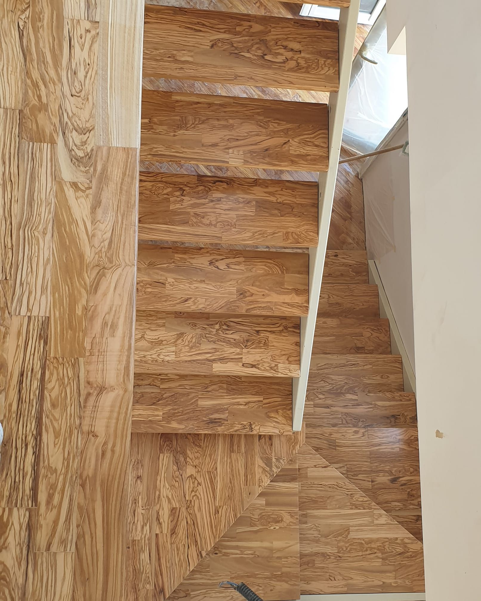 A wooden staircase with a white railing in a house.