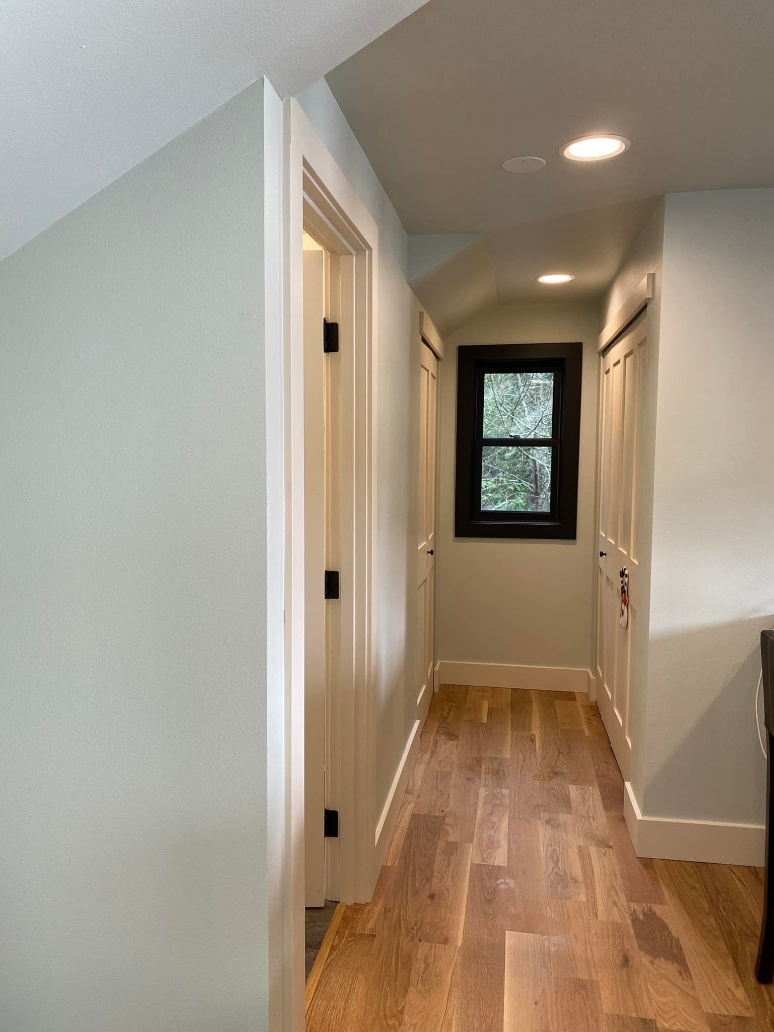 A hallway with hardwood floors and a window