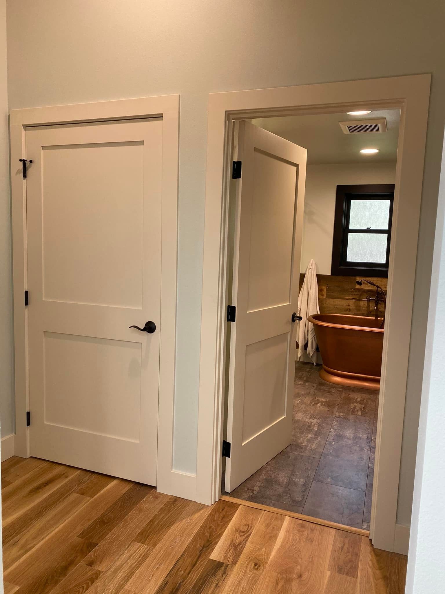 A bathroom with a copper tub and a window.