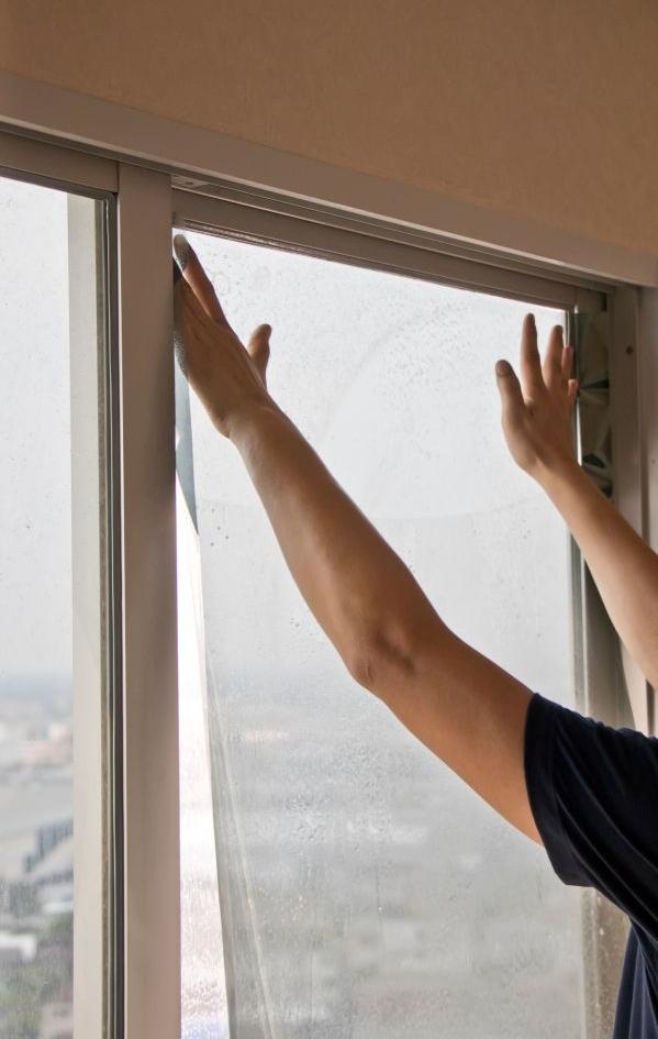 Person Installing Window Film — K & J Glass in Warrell Creek, NSW