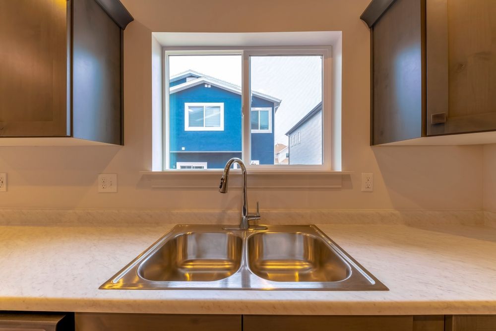 Kitchen Sink With a Window View of a Blue House — K & J Glass in Bellingen, NSW