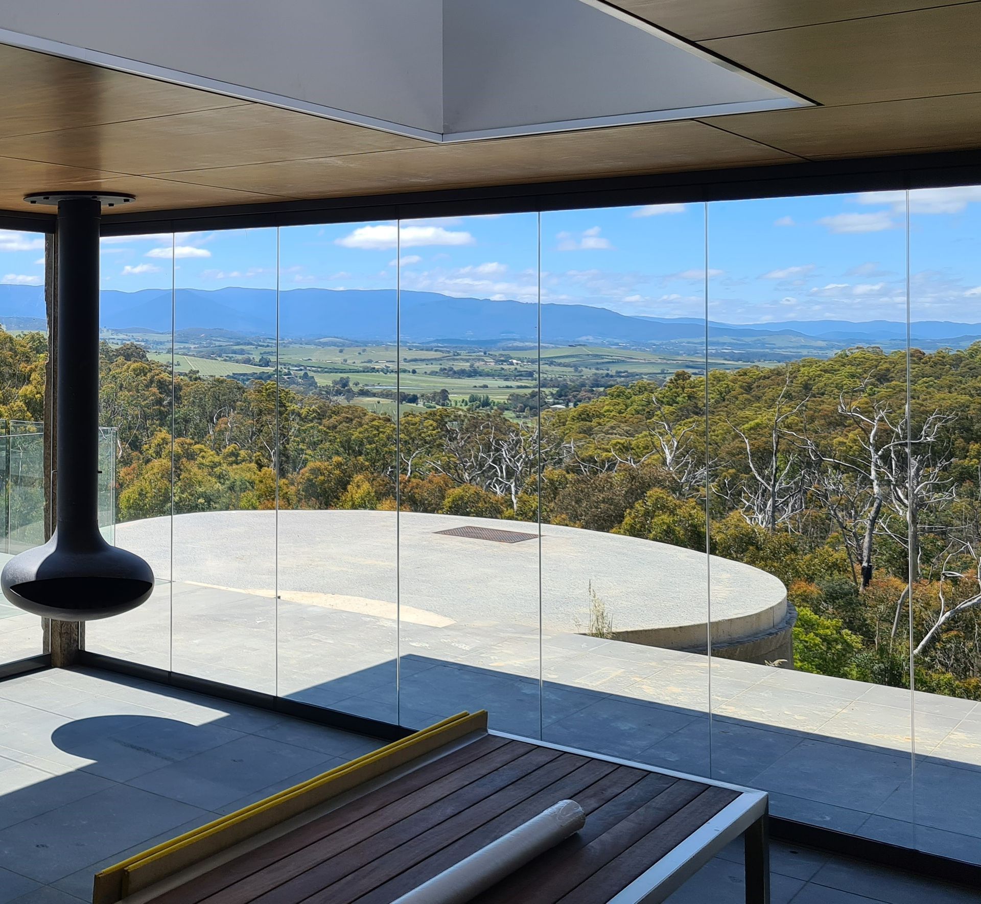 A Large bifold door with a fireplace looking out to a large piece of land — K & J Glass in Warrell Creek, NSW