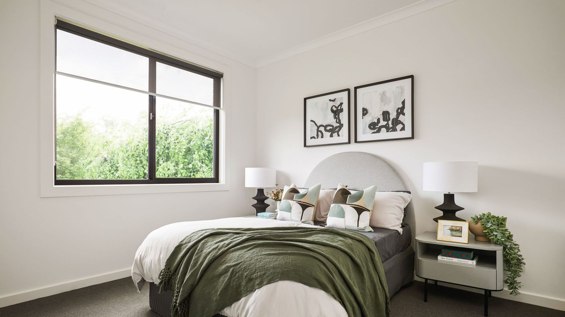 Bedroom with a gray bed, green blanket, and artwork above the headboard; window on the left — K & J Glass in Valla Beach, NSW