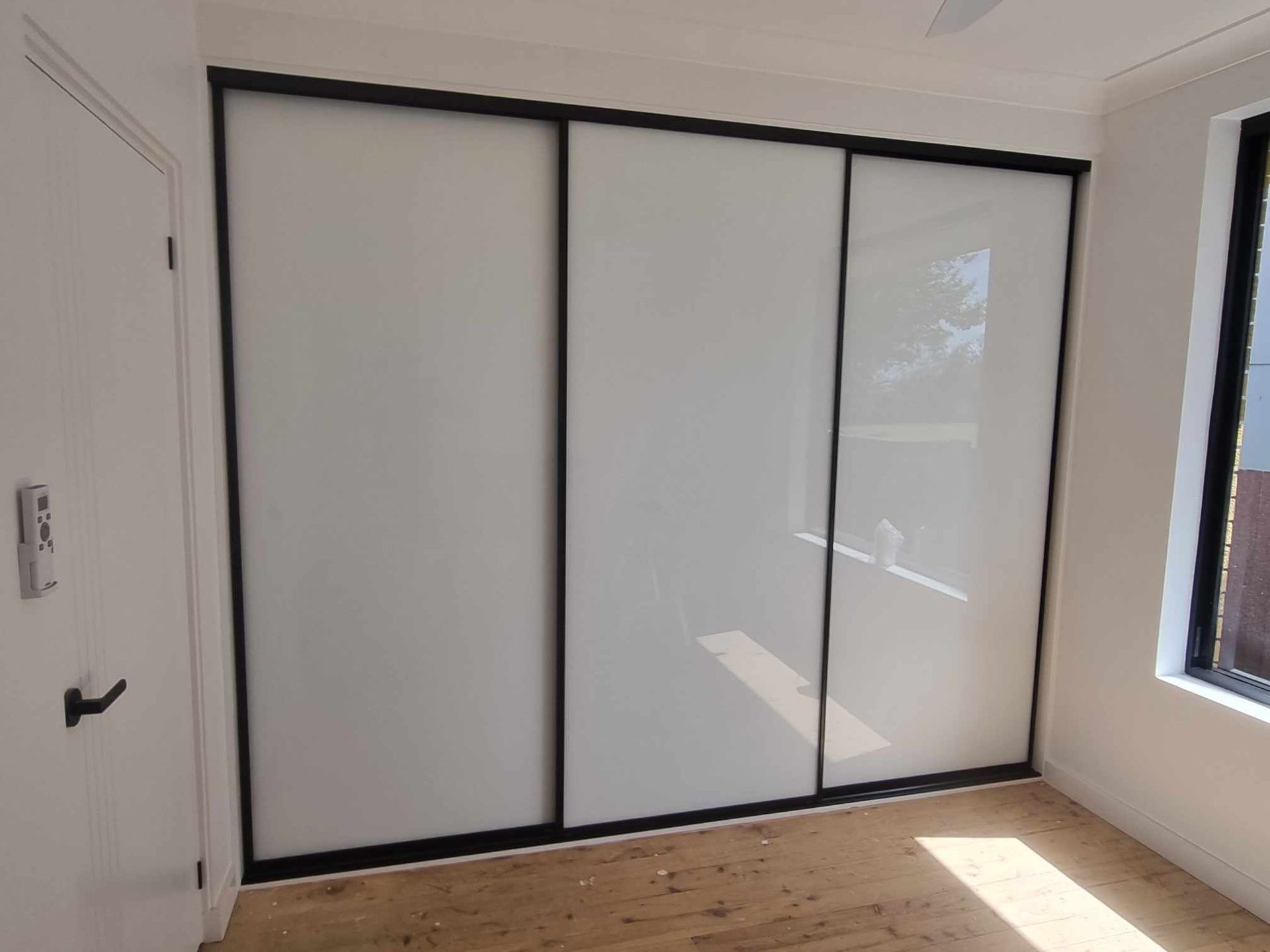 White Sliding Wardrobe Doors in a Bright Room — K & J Glass in Warrell Creek, NSW