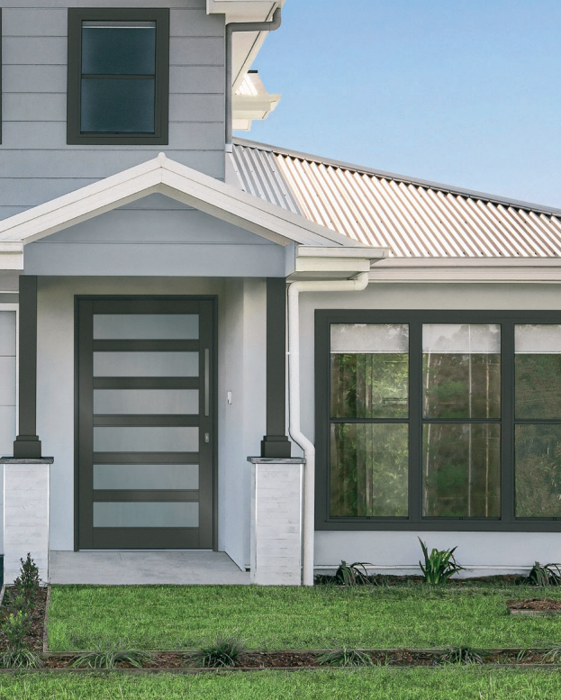 A Bradnams entrance door at the front of grey coloured house— K & J Glass in Warrell Creek, NSW
