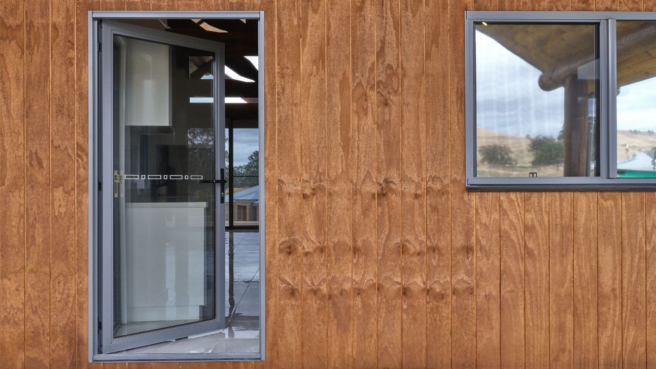 Hinged Door on a Wood-Paneled Building Exterior — K & J Glass in Warrell Creek, NSW