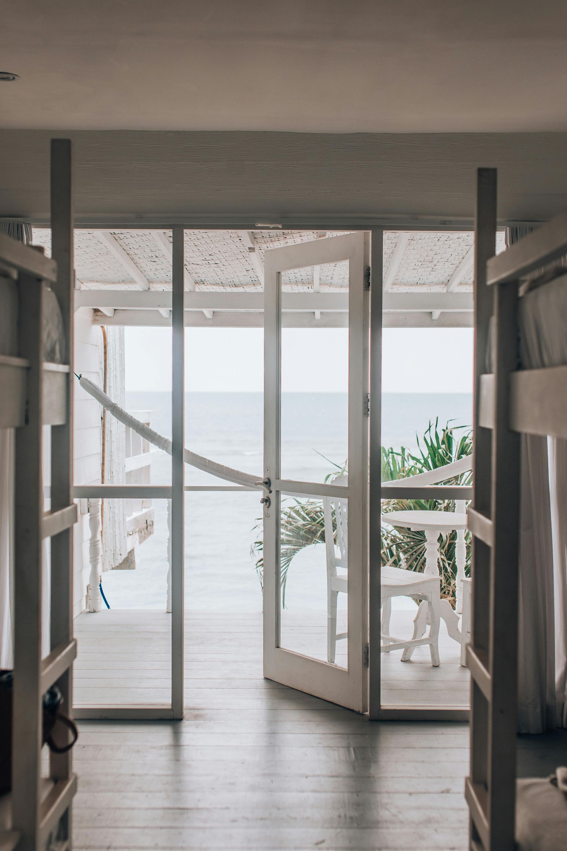 A white hinged door in modern styled beach house looking out to the ocean— K & J Glass in Warrell Creek, NSW