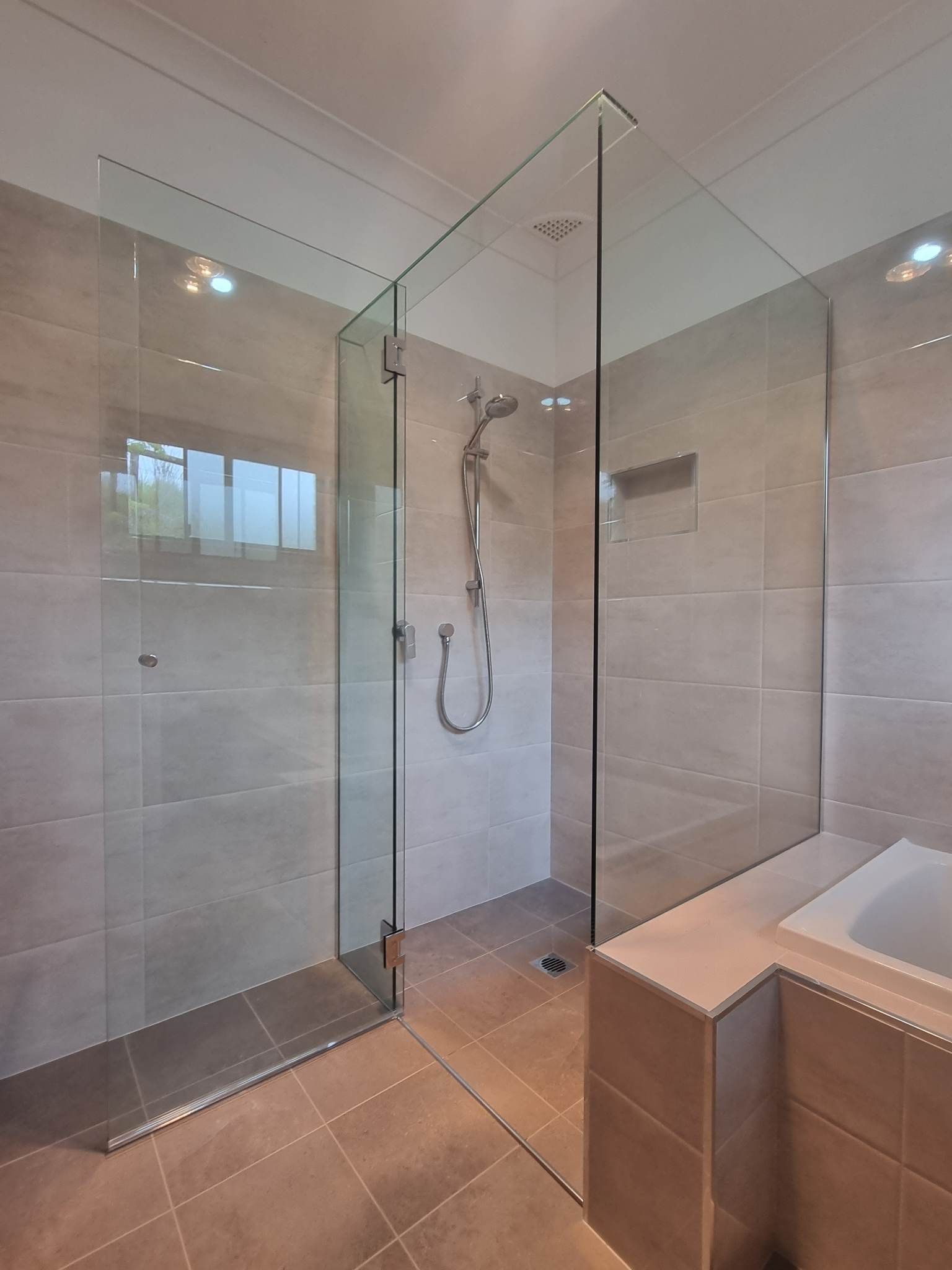 Glass-enclosed shower with tiled walls and floor — K & J Glass in Warrell Creek, NSW