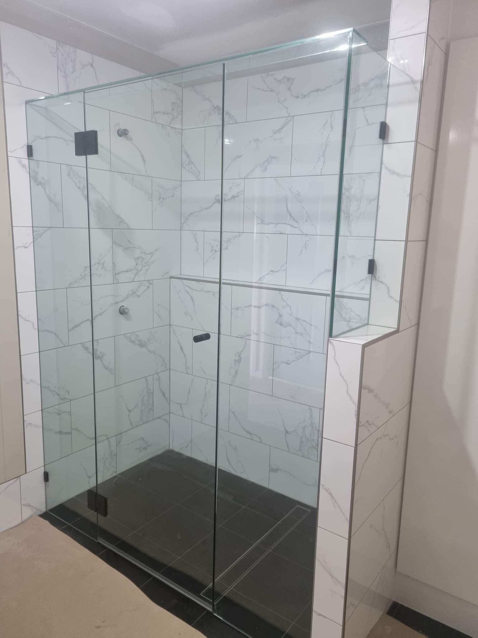 Glass Shower Enclosure in a Marble Tiled Bathroom — K & J Glass in Nambucca Heads, NSW