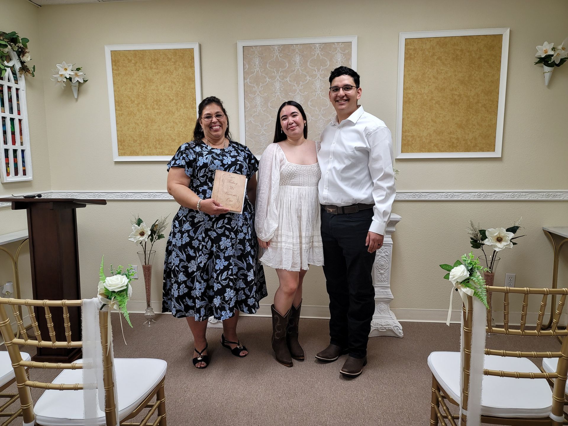 A newly married couple in the Elopement Chapel poses for a photo with Rev. Jennifer after their ceremony