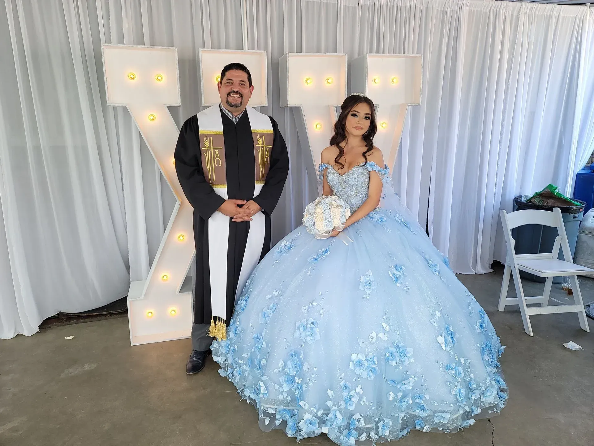 Man and woman pose in front of a light-up 