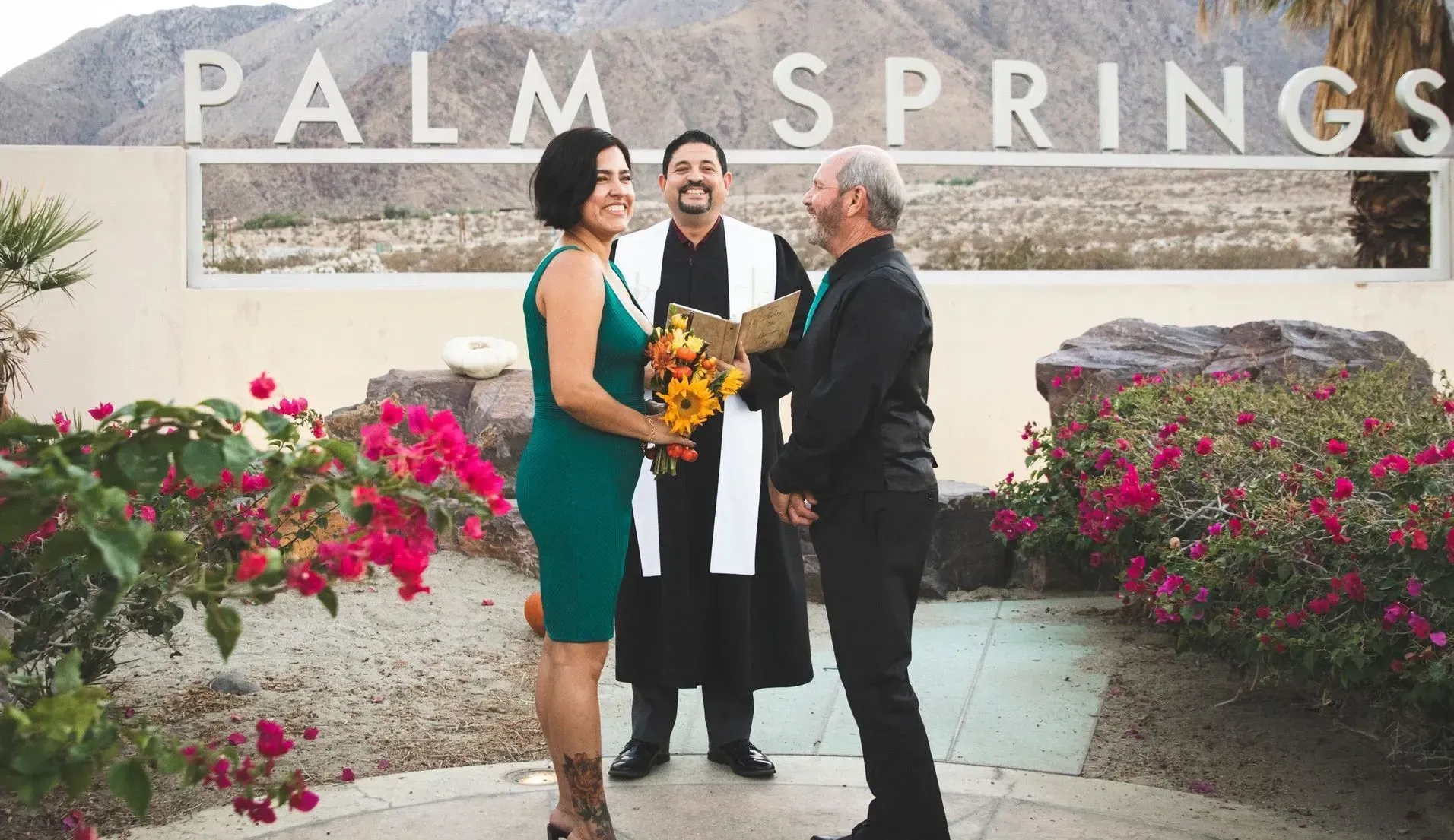 Rev. Steve with a couple eloping at the Palm Springs Sign near the Aerial Tram