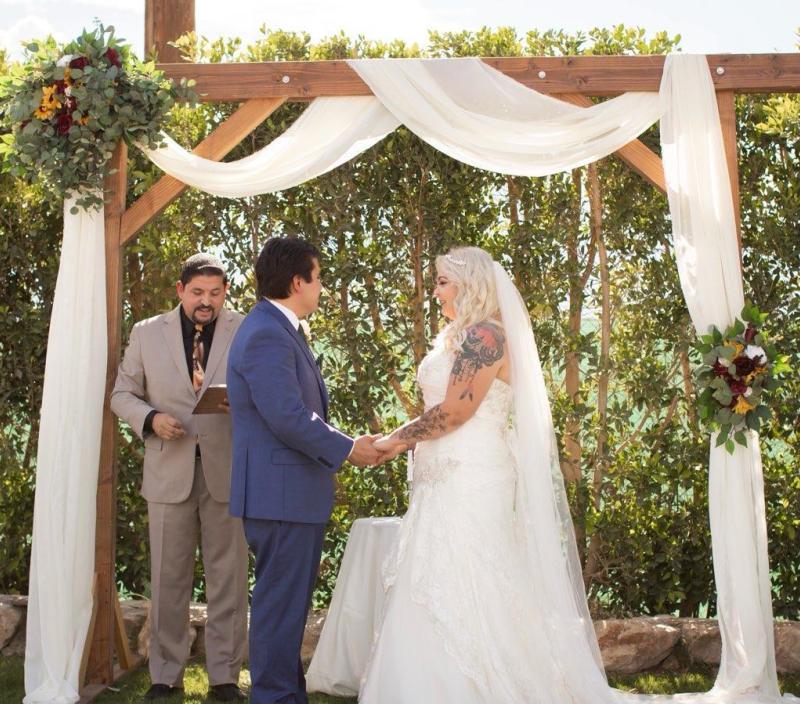 Couple under a Pergola Arch at Rancho El Refugio in Thousand Palms during a ceremony officiated by Rev. Steve