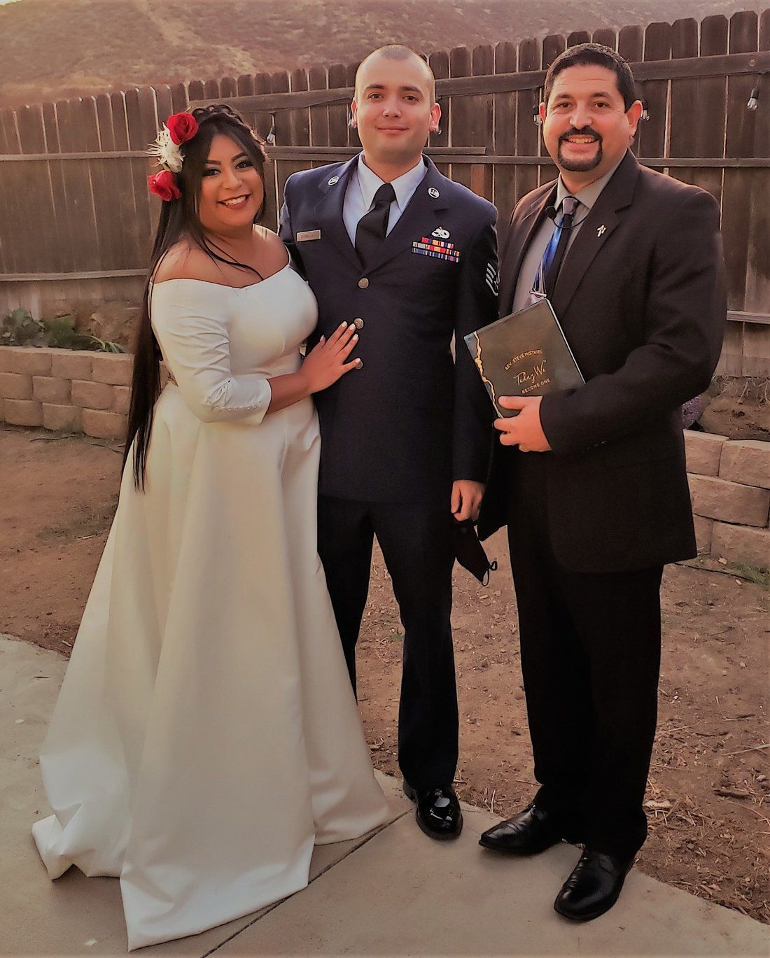 Navy Groom and His Wife pose with Rev Steve in sunset photo after their wedding ceremony