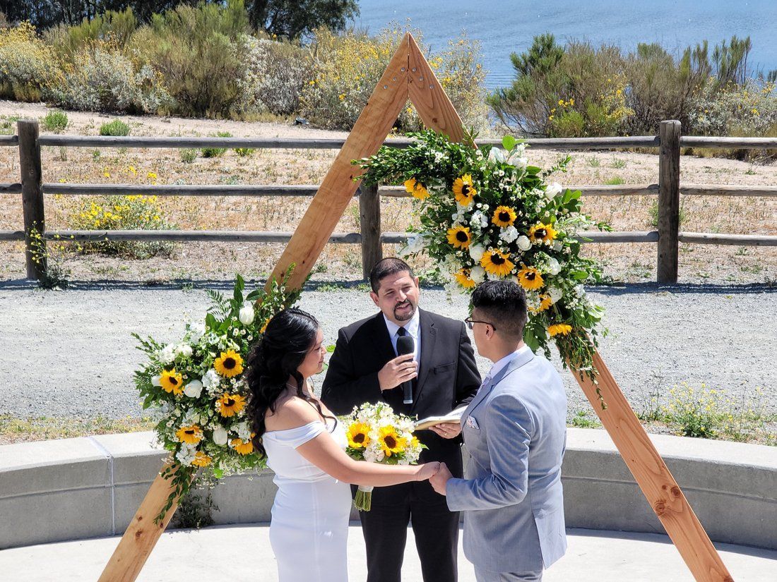 Sunflower bouquet and decorated Arch in front of the Lake background was the perfect setting for this couple's wedding day
