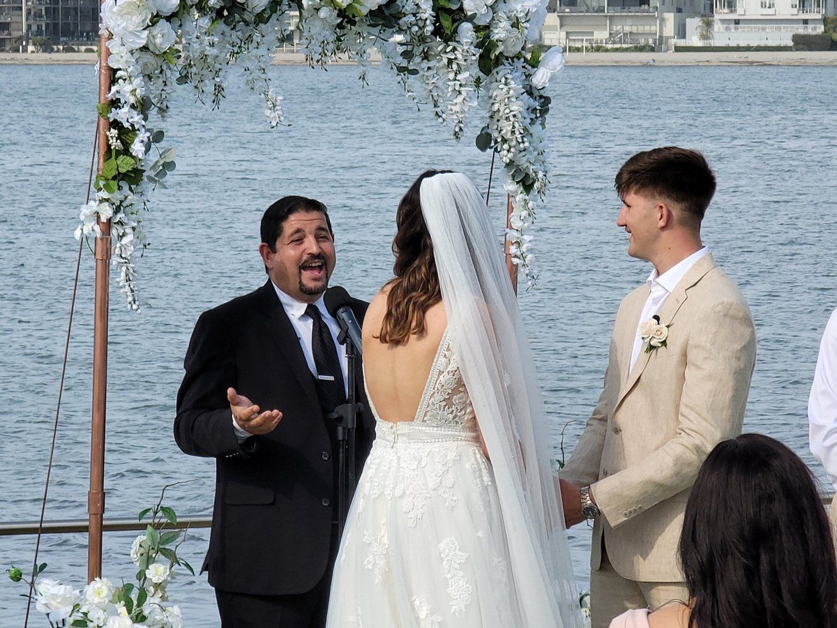 White Wisteria adorns the arch for the wedding ceremony given by Rev. Steve for these newlyweds.
