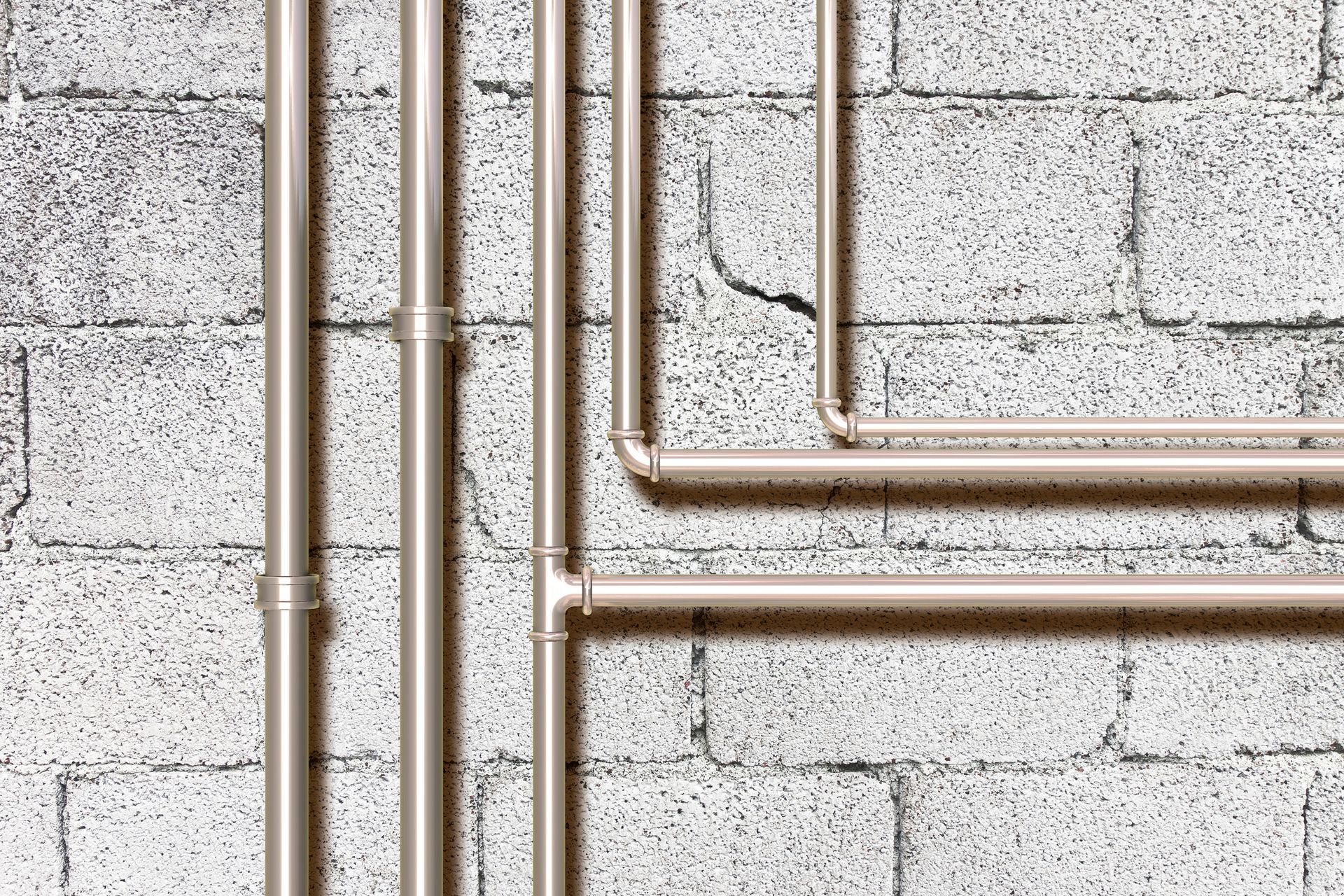 A bunch of pipes are connected to a brick wall.