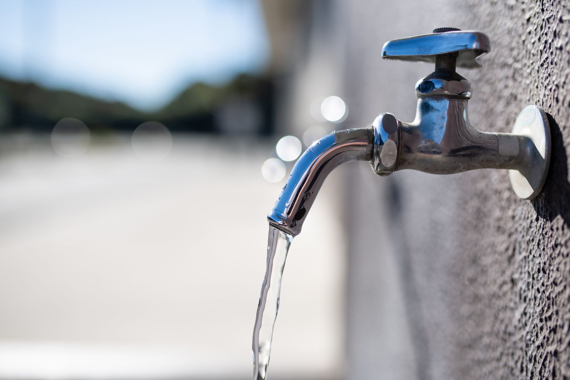 A close up of a water faucet with water running out of it.