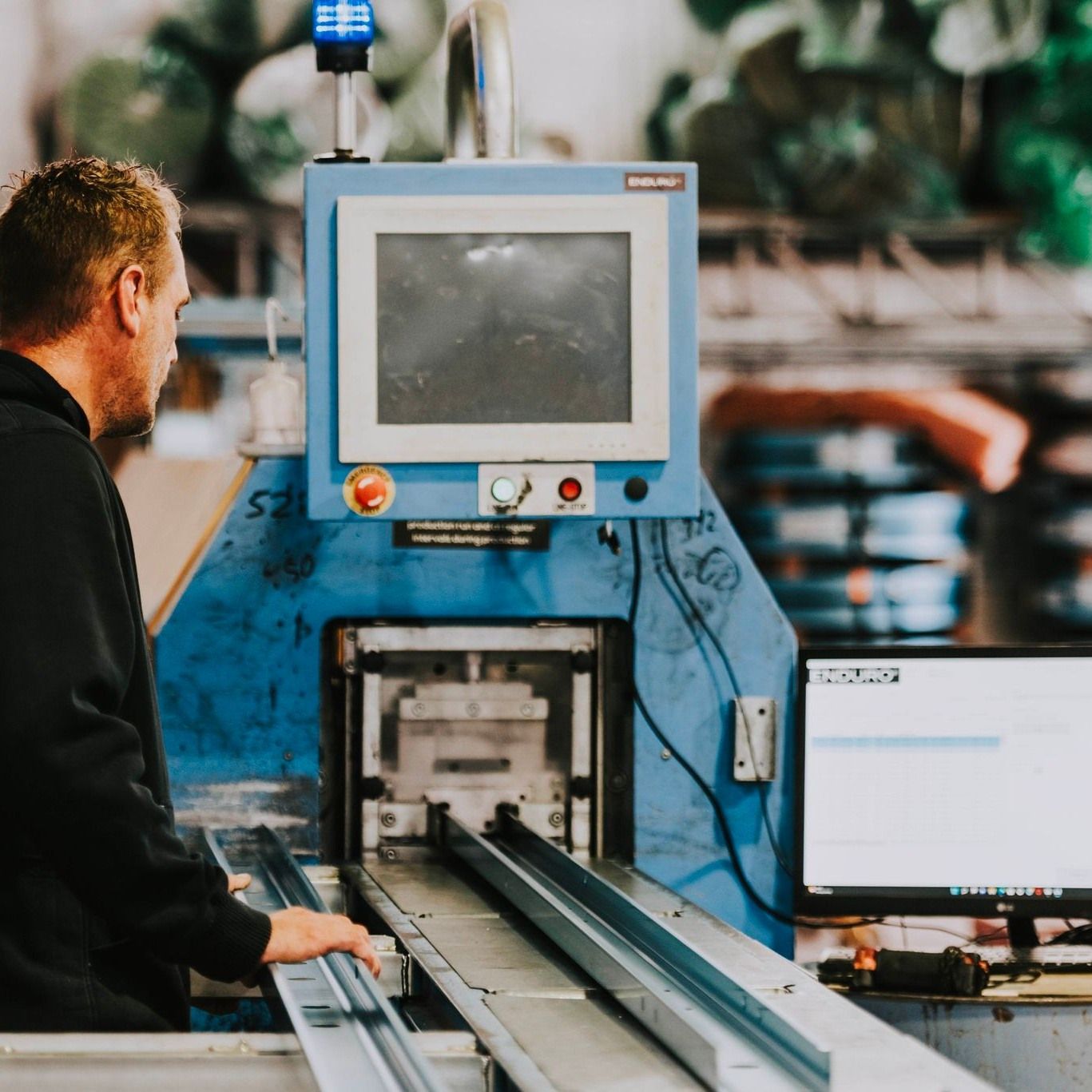 A Man is Working on a Machine With a Monitor on Top of It — Steel Frame Company In Parkes, NSW
