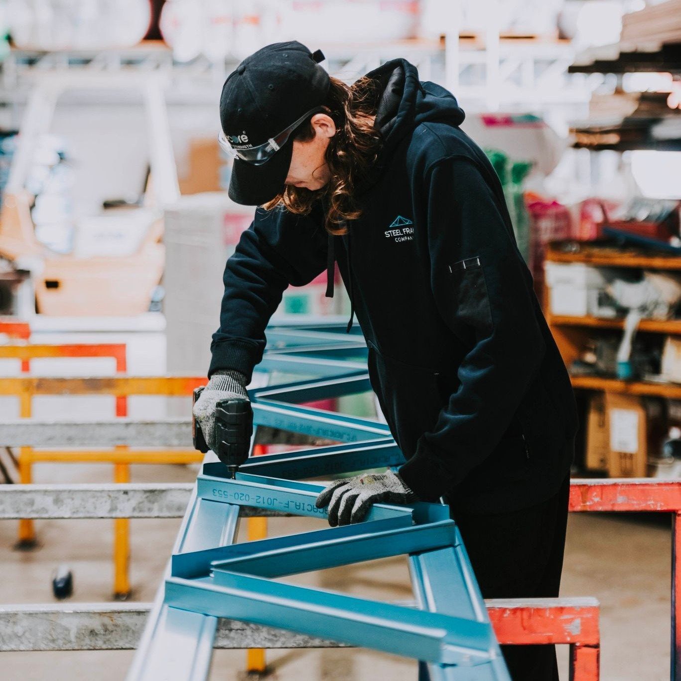A Man is Working on a Frame in a Factory — Steel Frame Company In Coonabarabran, NSW
