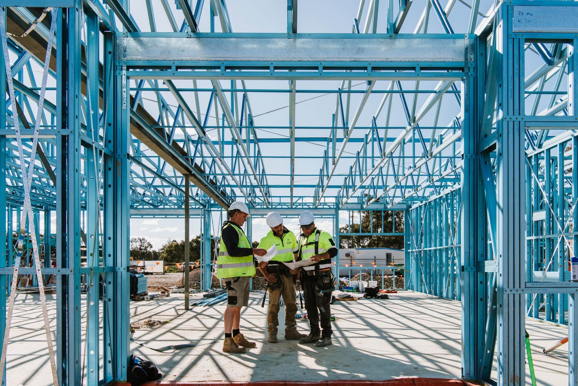 A Group of Construction Workers Are Standing Inside of a Building — Steel Frame Company In Forbes, NSW