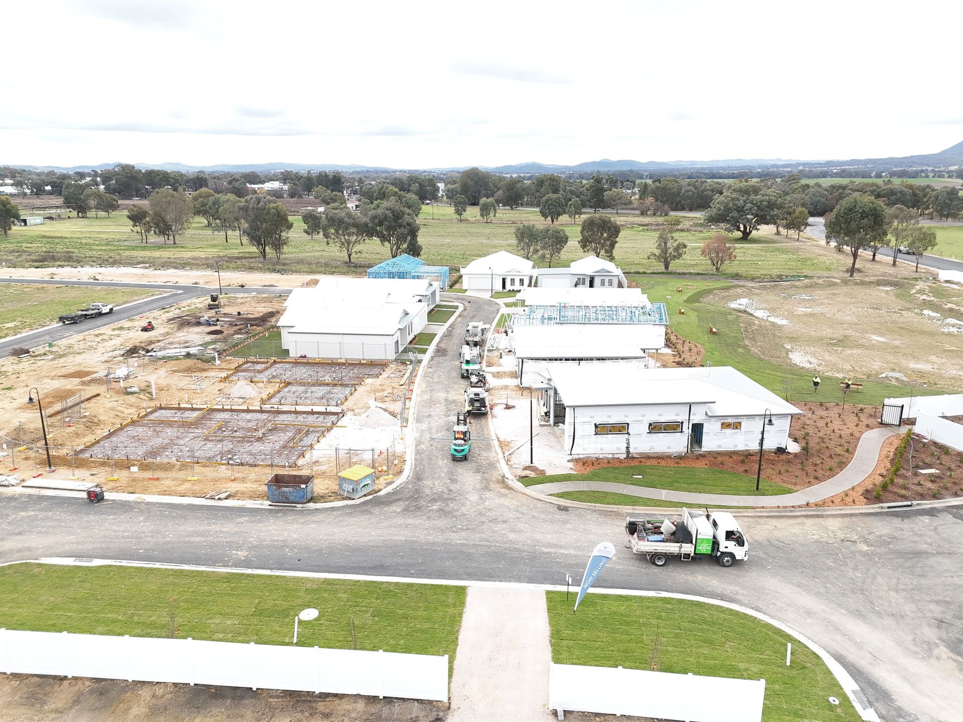 An aerial view of a construction site with a truck parked on the side of the road.