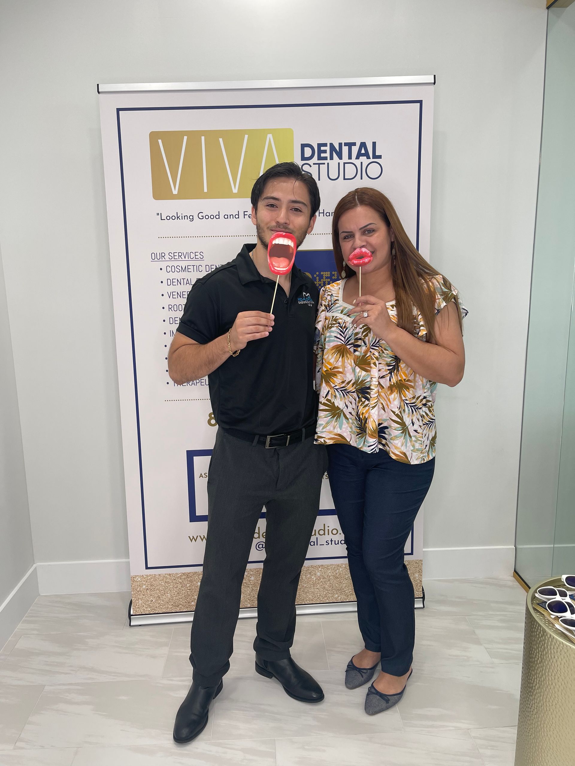 Man and woman pose with fake lips at Viva Dental Studio.