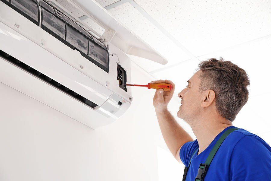 Air Conditioning System — Electrician Repairing Air Conditioner in Dallas, TX