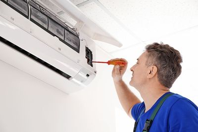 Air Conditioning System — Electrician Repairing Air Conditioner in Dallas, TX
