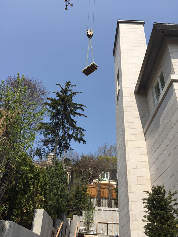 Un gros morceau de bois est soulevé par une grue